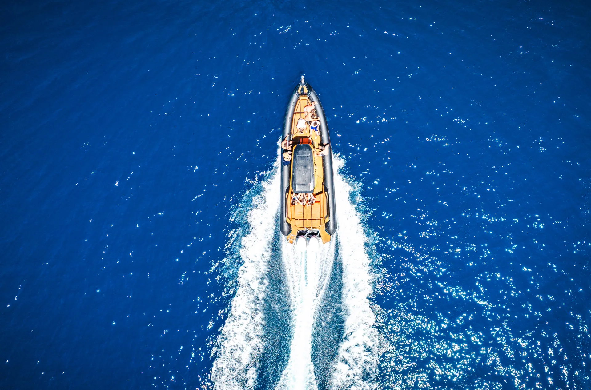 Aerial drone view of the Nemo Boat racing across the Saranda coastline of the Albanian Riviera