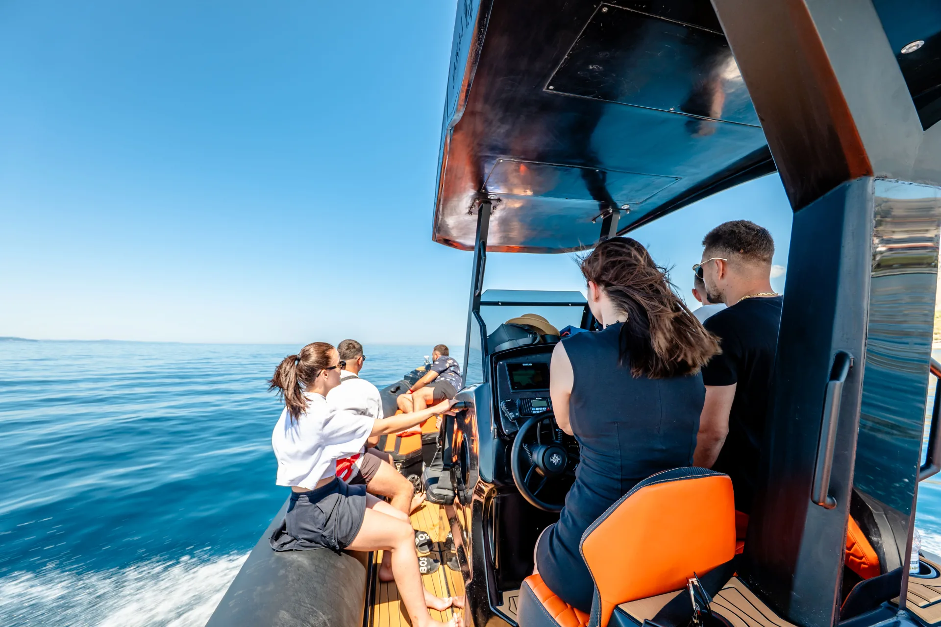 Wide-angle view from inside the Nemo Boat with guests and captain looking out to the Albanian Riviera